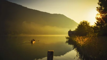 Ruderboot auf einem Bergsee im goldenen Abendlicht